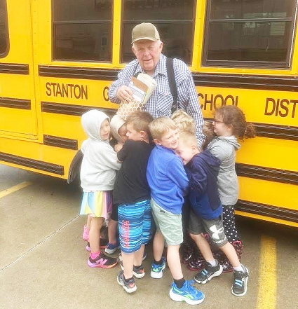 Tom Johnson, pictured above, gets hugs and gifts from the Good Shepherd Christian Preschool students following his retirement May 23. Johnson has spent more than 40 years driving a bus for the school.